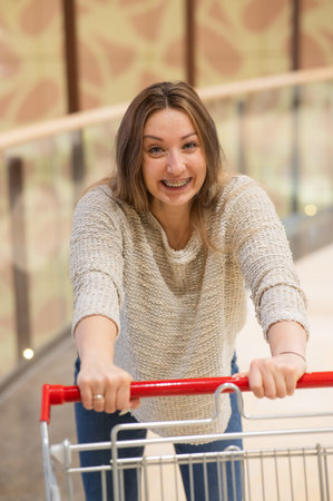 Caucasian woman with braces pushing shopping cartの写真素材