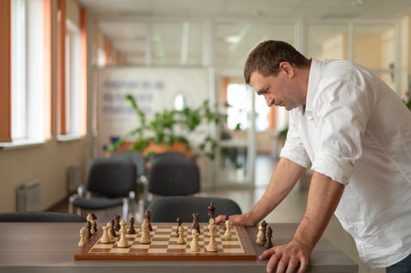 Caucasian man thinking about a chess moveの写真素材