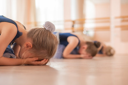 Caucasian little girls learn to dance at a ballet schoolの写真素材
