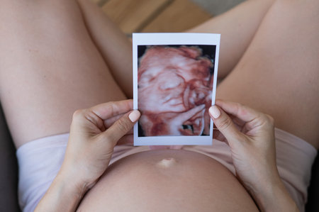 Pregnant woman holding 3d photo of baby with ultrasoundの写真素材