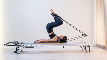Asian woman doing pilates on reformerの写真素材
