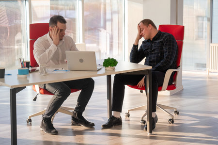 Two Caucasian men solve problems at work