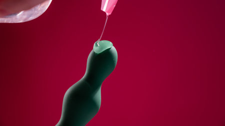 Lube pouring onto green anal beads on pink backgroundの写真素材