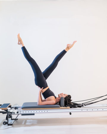 Asian woman doing pilates on reformer