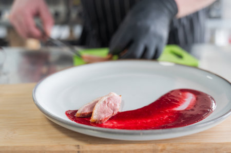 The chef places the duck on cranberry sauceの写真素材