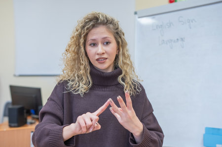 Caucasian female teacher communicates in Russian sign language with studentsの写真素材
