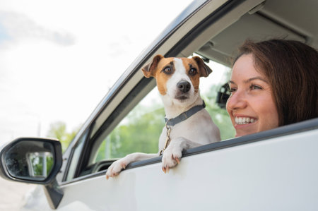 Caucasian woman looking out of car window with dog