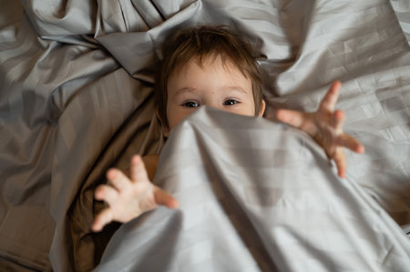 Top view of cute caucasian toddler lying in bed