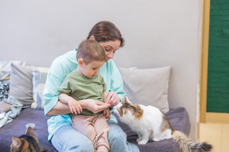 Caucasian woman with her son in a cat cafeの写真素材