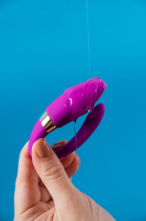 A woman holds a curved toy on a blue background.の写真素材