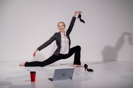 Barefoot ballerina dancing in business suit on white backgroundの写真素材