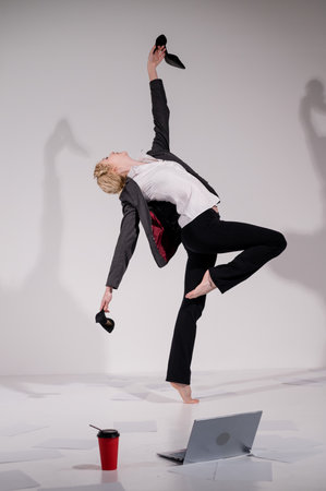 Barefoot ballerina dancing in business suit on white backgroundの写真素材