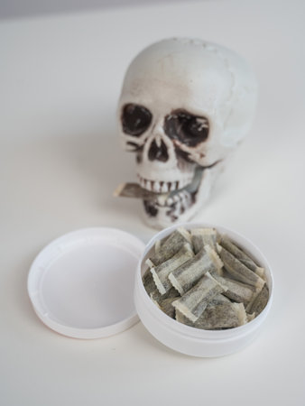 Skull Chewing Tobacco on a White Tableの写真素材