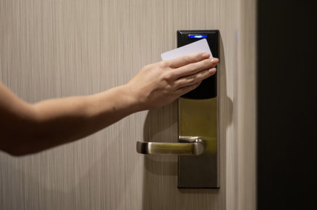 A woman opens an electronic lock with a card and enters a hotel roomの写真素材