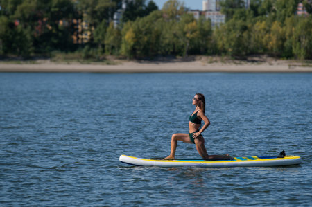 Caucasian woman doing yoga on a SUP boardの写真素材