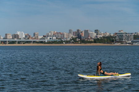 Caucasian woman doing yoga on a SUP board