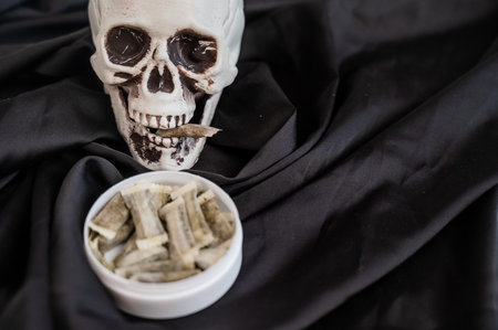 Skull Chewing Tobacco on Black Clothの写真素材