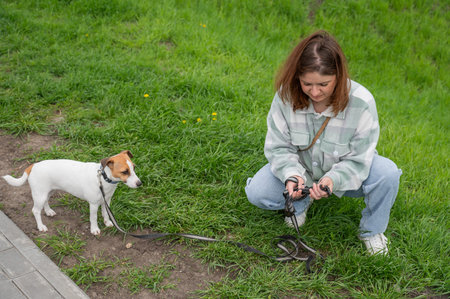 A woman holds a dog waste dispenser while out for a walk.の写真素材