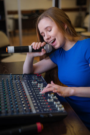 Young woman mixing live sound. Girl recording a song in the studio