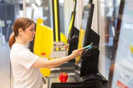A woman pays using her smartphone at a self-checkoutの写真素材