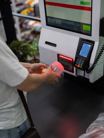 A woman scans items at a self-checkoutの写真素材