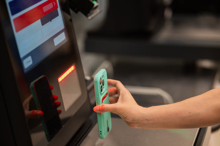 Woman scanning discount on phone at self-checkoutの写真素材
