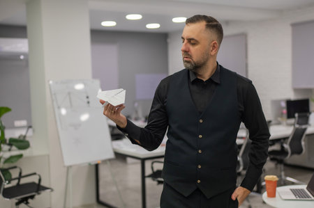 Caucasian man launching paper airplane in officeの写真素材