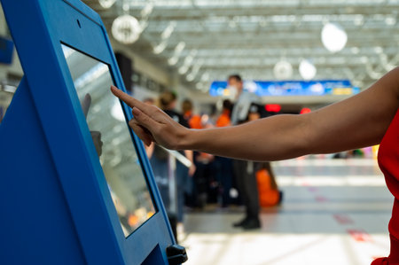 Interacting with a touchscreen kiosk at an airportの写真素材