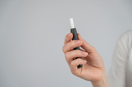 Faceless woman holding tobacco heating systemの写真素材