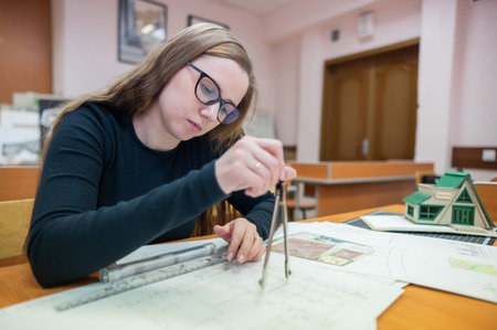 Caucasian young woman making drawings. Student of architecture university