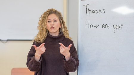 Caucasian female teacher communicates in Russian sign language with studentsの写真素材