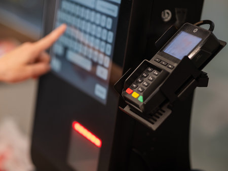 A woman uses a self-checkout machineの写真素材
