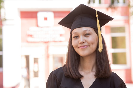 Happy young asian woman in graduation gown