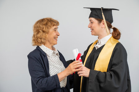 Portrait of Caucasian woman in graduation gown with her motherの写真素材