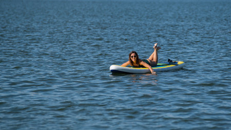Caucasian woman posing on a SUP board. Summer sportの写真素材