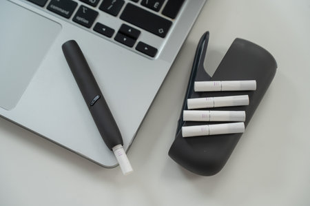Tobacco heating system next to a laptopの写真素材