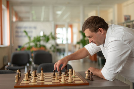 Caucasian man thinking about a chess moveの写真素材