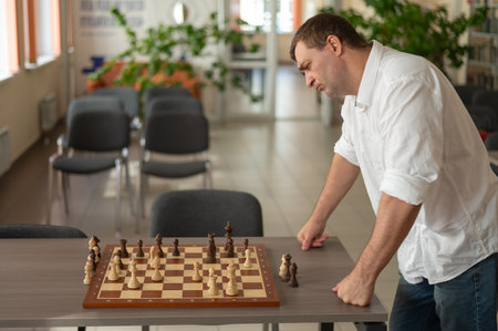 Caucasian man thinking about a chess moveの写真素材