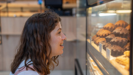 woman looks at baked goods in a bakeryの写真素材