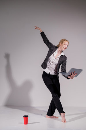 Barefoot ballerina dancing in business suit on white backgroundの写真素材