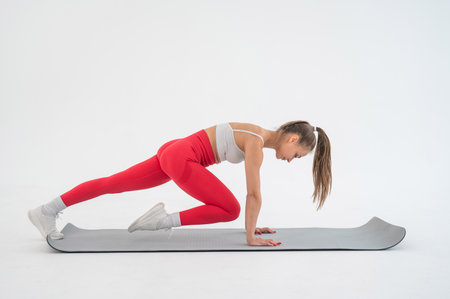 Young woman doing plank exercise on white backgroundの写真素材