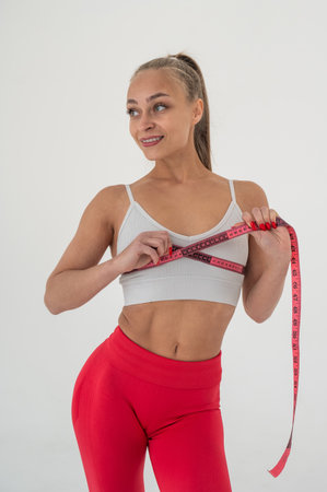 Young woman measuring her chest circumference on white backgroundの写真素材
