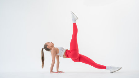 Caucasian woman doing sports exercises on white backgroundの写真素材