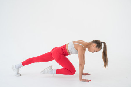 Young woman doing plank exercise on white backgroundの写真素材