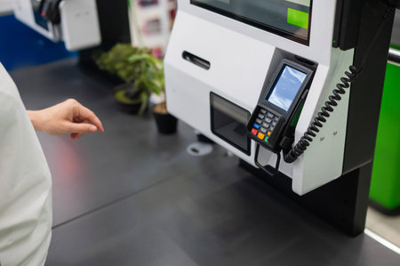 A woman uses a self-checkout machine