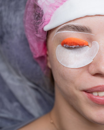 Caucasian woman undergoing eyelash lamination procedure. top view