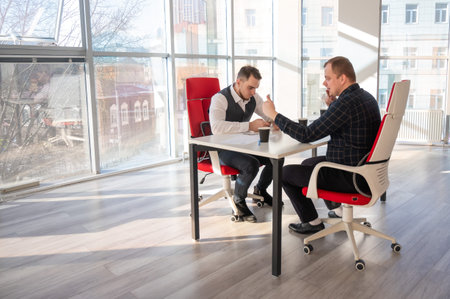 Two men using smartphones while sitting at a desk