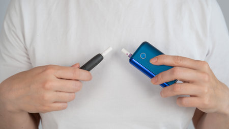 A person compares two different electronic cigarette devices.
