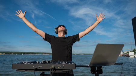 Caucasian man works as a DJ on the beach