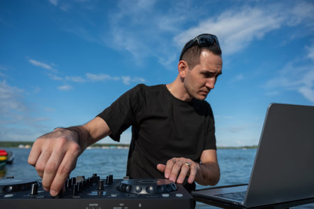 Caucasian man works as a DJ on the beach
